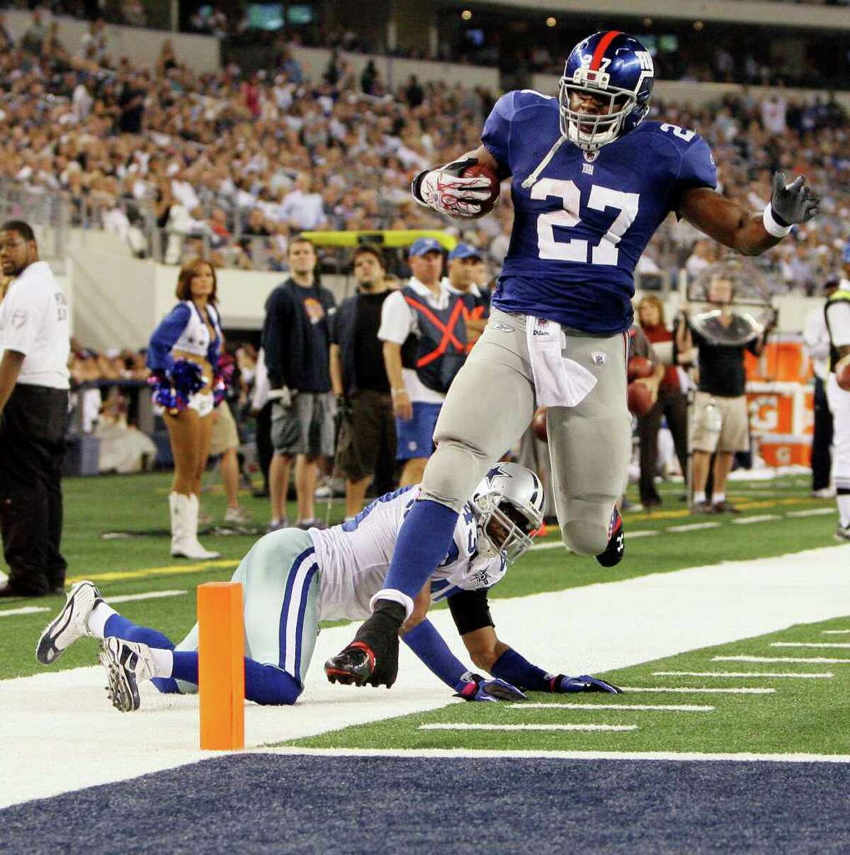 New York Giants running back Brandon Jacobs scores a touchdown as Dallas Cowboys safety Gerald Sensabaugh defends during the second half an NFL football game Monday, Oct. 25, 2010, in Arlington, Texas. New York won 41-35. (AP Photo/LM Otero)
