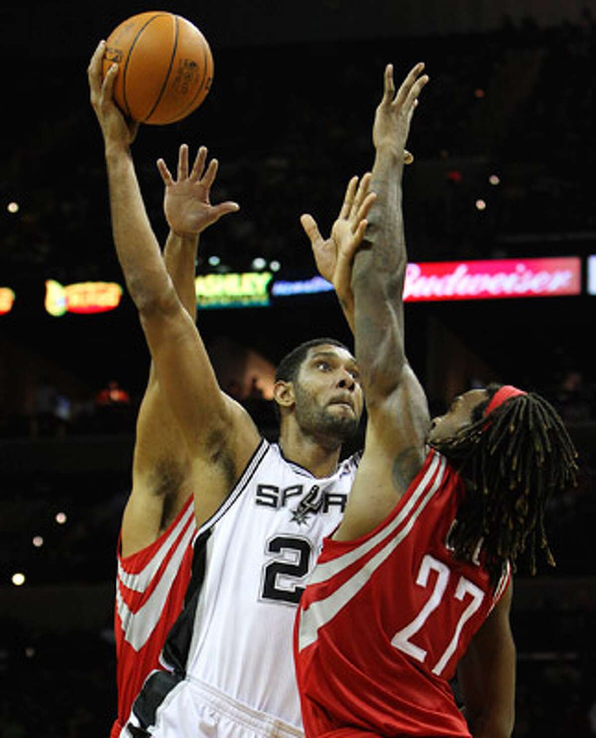 The Spurs’ Tim Duncan (center) puts up a shot over the Rockets’ Jordan Hill (27) in Thursday’s preseason game.