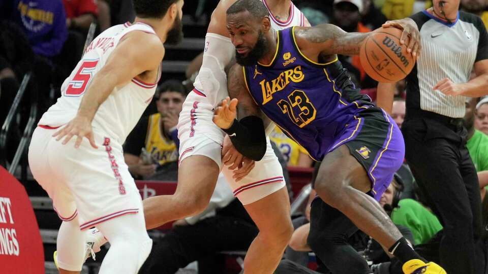 Los Angeles Lakers forward LeBron James (23) drives the ball against Houston Rockets forward Dillon Brooks (9) in front of guard Fred VanVleet (5) during the first half on an NBA basketball game, Wednesday, Nov. 8, 2023, in Houston.