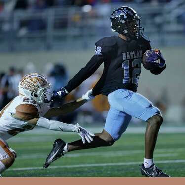 Harlan Hawks Taveion Ford (12) evades Eagles Pass Eagles Adrian Rodriguez on his 53 yard touchdown run in Class 6A Division II bi-district playoff football game between Harlan (29-6A champ) and Eagle Pass (30-6A lower seed on Thursday, Nov. 9, 2023 at Farris Stadium. Harlan defeated Eagle Pass 27-20.