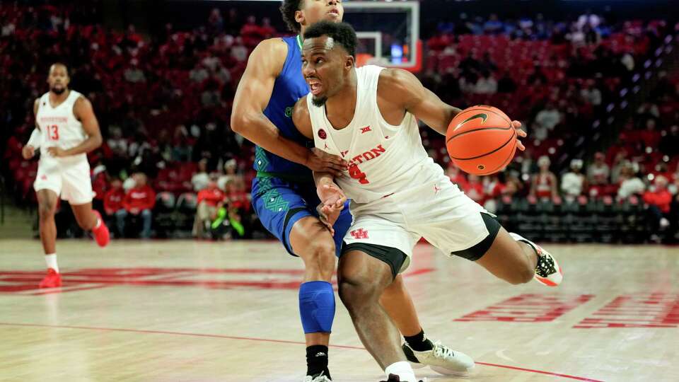 Houston guard LJ Cryer (4) drives the ball against Texas A&M-CC guard Jordan Roberts (2) during the first half of an NCAA college basketball game at the Fertitta Center, Saturday, Nov. 11, 2023, in Houston.