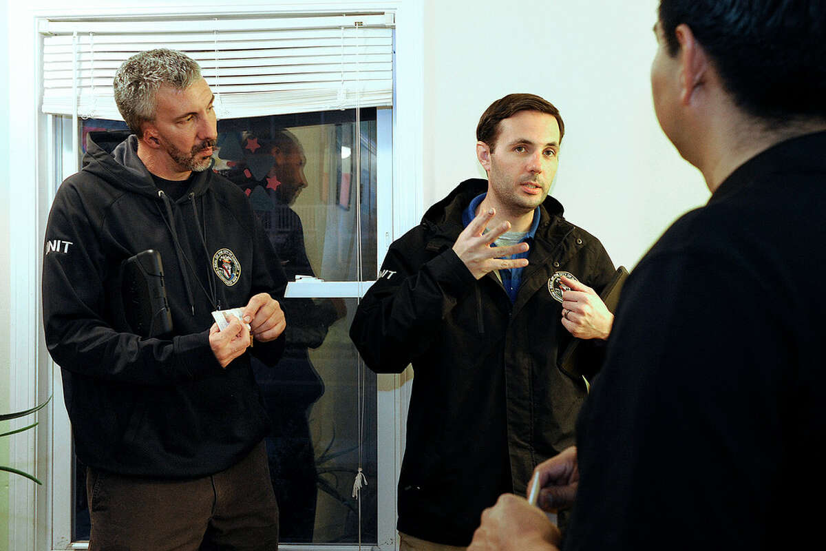 Shawn Stillman, left, coordinator of Danbury's Unified Neighborhood Inspection Team, and Jeff Preston, also with the U.N.I.T., speak with landlord Julio Macancela about the three-family home on Sheridan Street in Danbury, Thursday, Nov. 30, 2017.