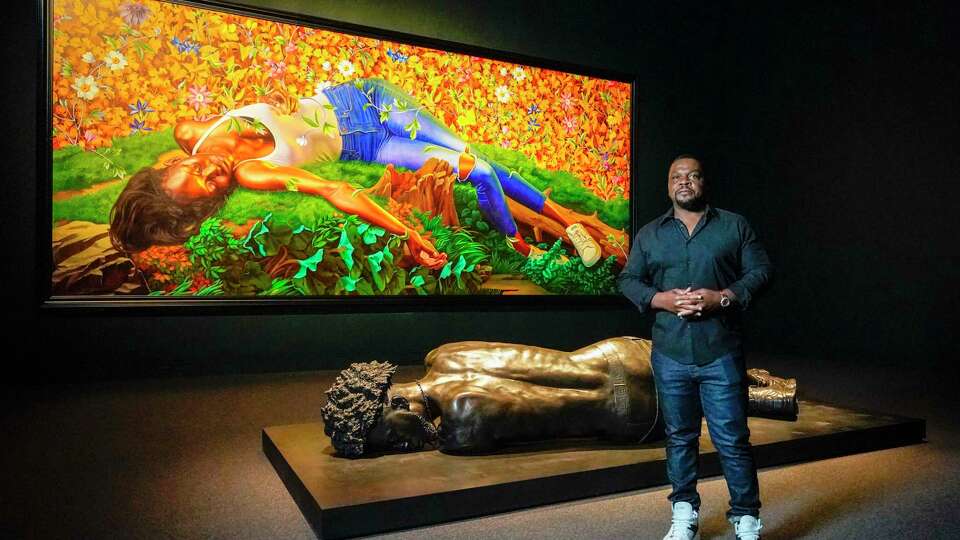 Kehinde Wiley stands by Young Tarentine II (Ndeye Fatou Mbaye (oil on canvas) as well as The Birgin Martyr St. Cecilia (bronze) as he walked through his new show, An Archeology of Silence at Museum of Fine Arts Houston on Tuesday, Nov. 14, 2023, in Houston.