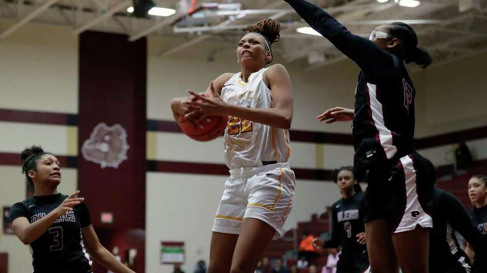 Summer Creek's Zachara Perkins, center, drives up a shot between Pearland's Nyah Hardy (3) and Eliece Perry, right, during their non-district high school basketball game Tuesday, Nov. 14, 2023 held at Summer Creek High School in Houston.