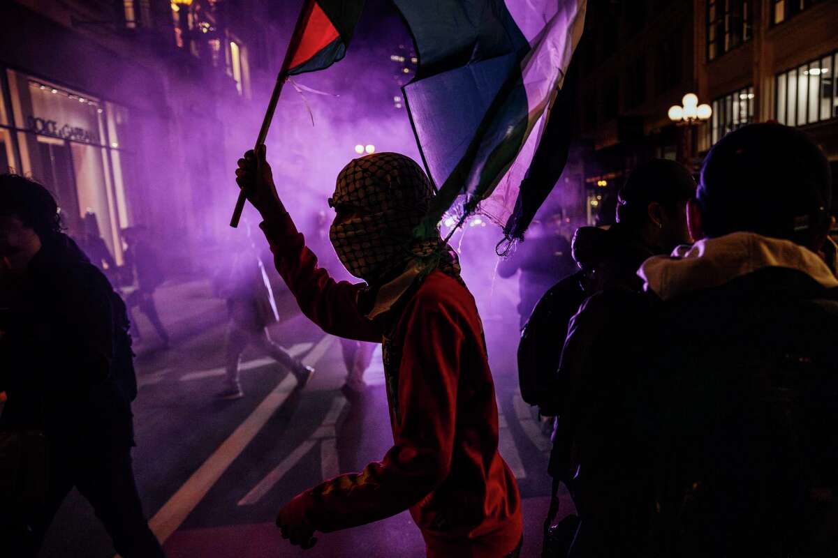 A protestor holds a Palestine flag during a rally demanding a ceasefire of the ongoing Israeli-Palestine conflict, as the 2023 Asia-Pacific Economic Cooperation Economic Leaders’ Week (APEC) is underway in San Francisco, Tuesday, Nov. 14, 2023.