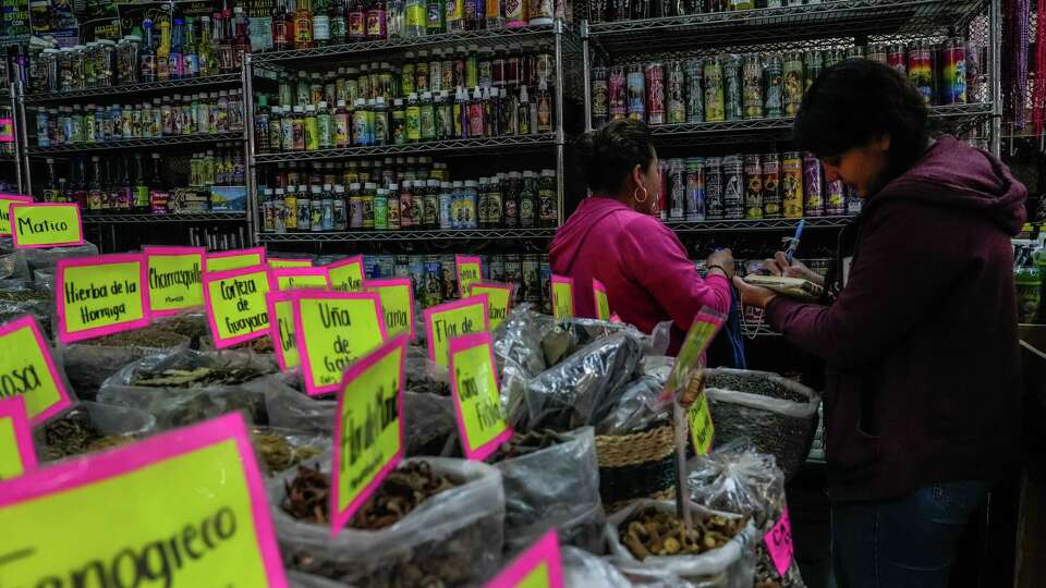 Juana Lopez and her coworker take inventory of products being sold at the Aztec Farmers Market on Wednesday, Nov. 15, 2023, in Houston.