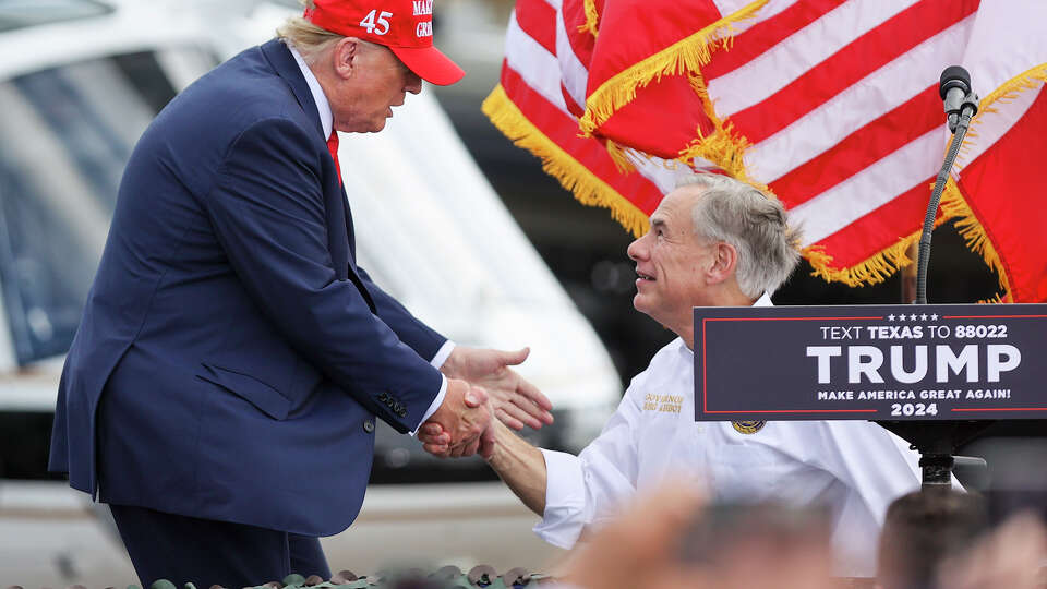 Former President Donald J. Trump shakes hands with Texas Governor Gregg Abbott while coming onto stage after receiving Abbotts's endorsement for President during a rally at the South Texas International Airport in Edinburg, TX, on Sunday, Nov. 19, 2023.