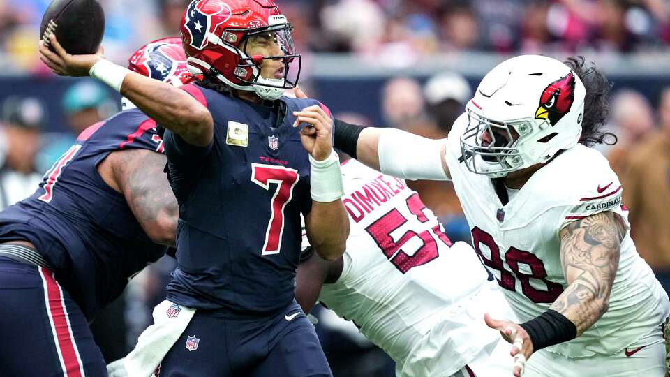 Houston Texans quarterback C.J. Stroud (7) throws a pass as he is pressured by Arizona Cardinals defensive tackle Roy Lopez (98) during the first half of an NFL football game Sunday, Nov. 19, 2023, in Houston.