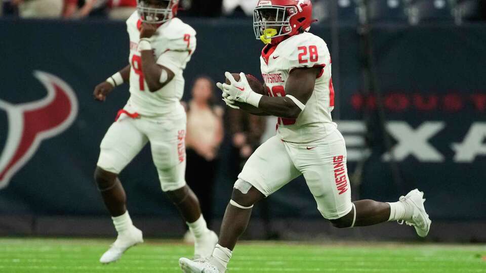 North Shore running back D'andre Hardeman Jr. (28) runs the ball as quarterback Kaleb Bailey looks on during the second half of a Region III-6A Division 1 semifinal high school football playoff game at NRG Stadium, Friday, Nov. 24, 2023, in Houston.