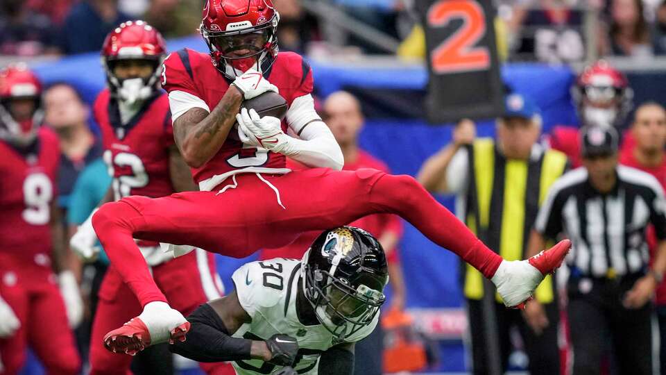 Houston Texans wide receiver Tank Dell (3) hauls in a reception for a first down over Jacksonville Jaguars cornerback Montaric Brown (30) during the first half of an NFL football game Sunday, Nov. 26, 2023, in Houston.