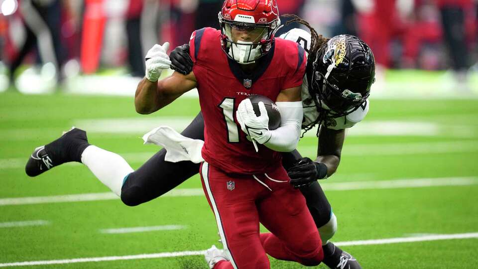 Houston Texans wide receiver Xavier Hutchinson (19) makes a catch against Jacksonville Jaguars safety Rayshawn Jenkins (2) during the second half of an NFL football game Sunday, Nov. 26, 2023, in Houston.