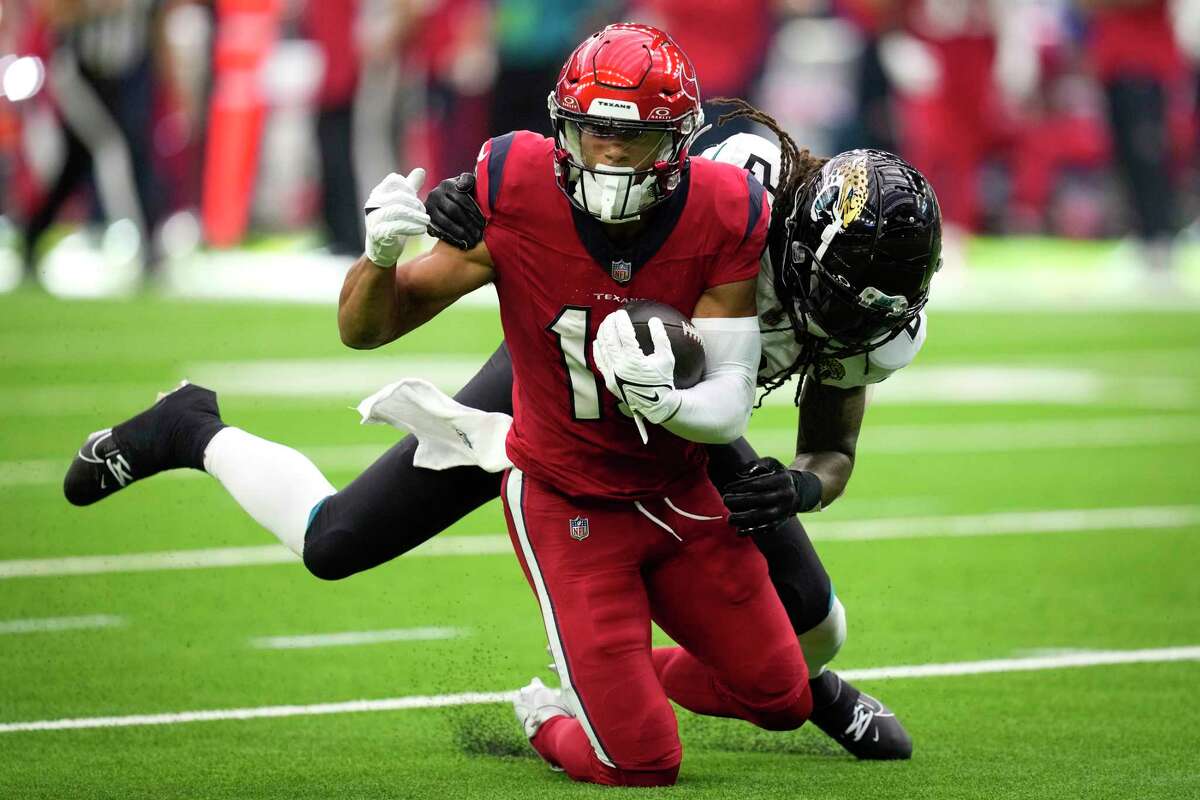 Houston Texans wide receiver Xavier Hutchinson (19) makes a catch against Jacksonville Jaguars safety Rayshawn Jenkins (2) during the second half of an NFL football game Sunday, Nov. 26, 2023, in Houston.