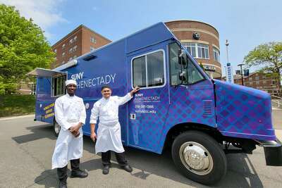 SUNY Schenectady culinary student Ngambela Zulu, and Chef Giovanni Lontoc, pause outside of the college’s mobile food service truck on campus.