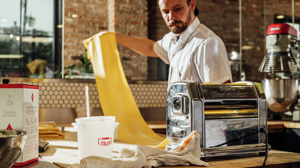 A chef at Ostia rolls out a sheet of pasta