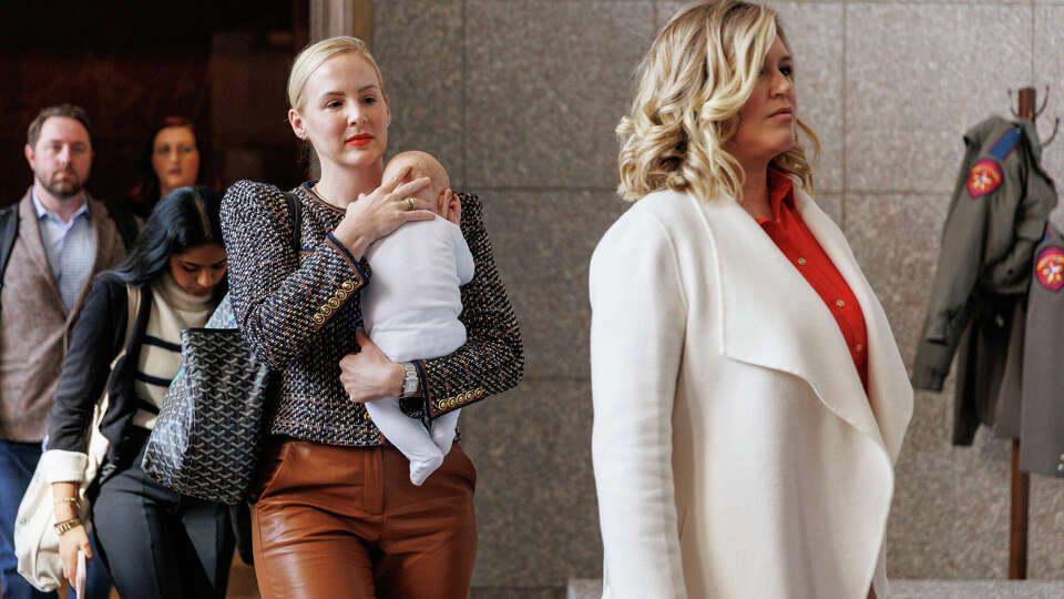 Dr. Austin Dennard of Dallas holds her son as they walk out of the Texas Supreme Courtroom with Lauren Miller of Dallas on Tuesday, Nov. 28, 2023, in Austin, Texas. Both women are part of the Zurawski v. Texas case, a major challenge to the state's bortion ban led by more than 20 women suing for clarified medical exemptions. The women on the lawsuit, which was filed in March, say they were denied care and their health was jeopardized because the law is overly vague.