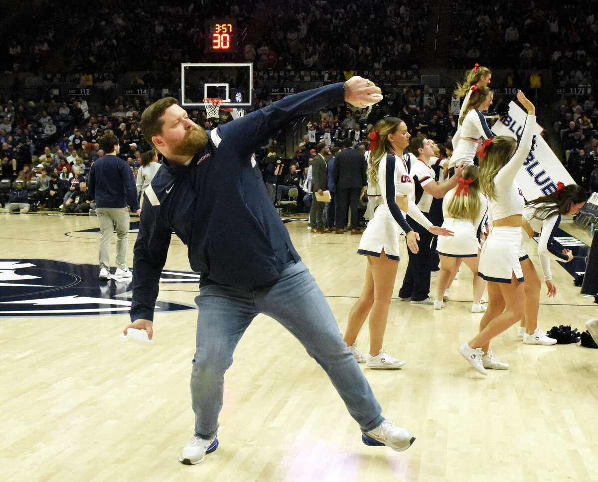 On-court host Conor Geary throws T-shirts into the crowd during UConn's men's basketball game at Gampel Pavilion in Storrs, Conn. Monday, Nov. 27, 2023.