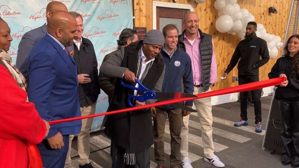 Cannabis retailer Higher Collective owner Kevin Henry cuts the ribbon on his new Hartford store flanked by elected officials on Nov. 29, 2023. 