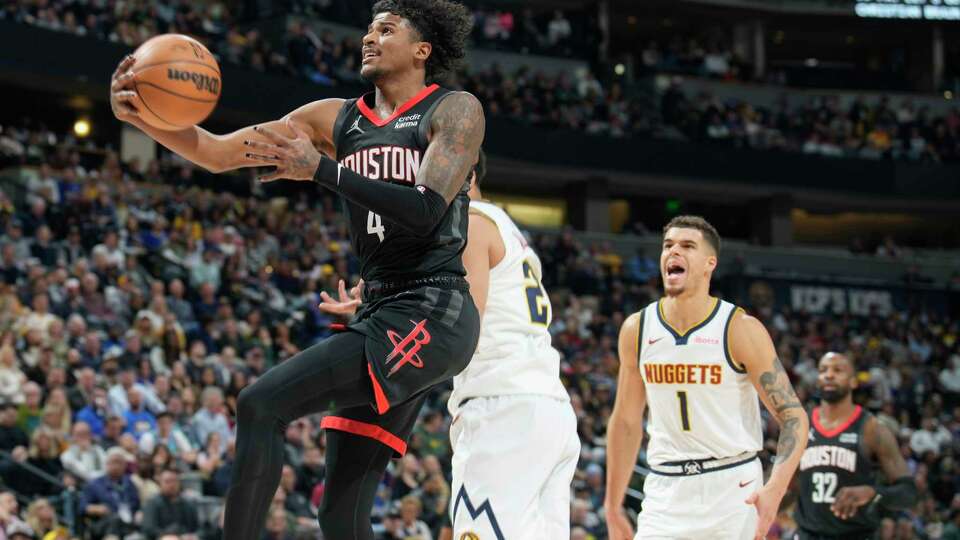 iHouston Rockets guard Jalen Green, left, drives to the rim past Denver Nuggets forwards Zeke Nnaji and Michael Porter Jr. in the second half of an NBA basketball game on Wednesday, Nov. 29, 2023, in Denver. (AP Photo/David Zalubowski)