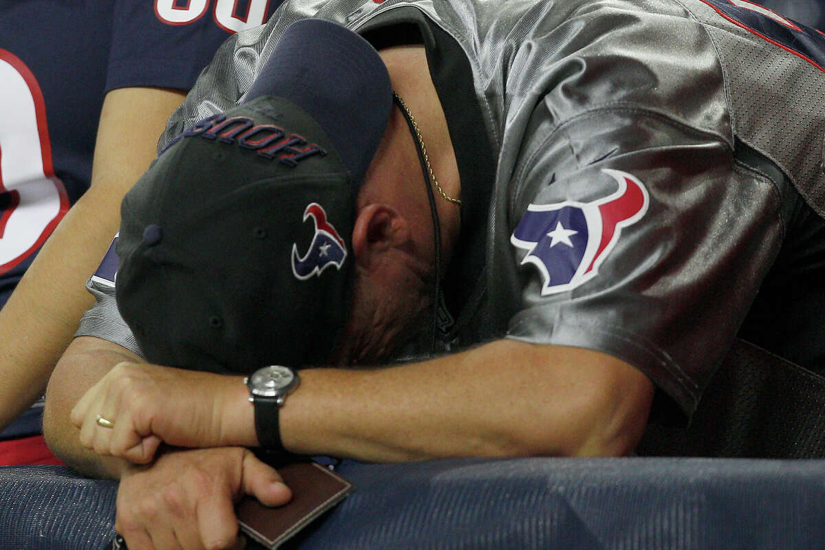 A Houston Texans fan bends over dejected after the Indianapolis Colts defeated the Houston Texans in a NFL game on October 9, 2014 at NRG Stadium in Houston, Texas.