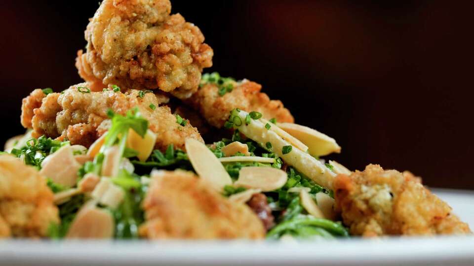 The fried oyster salad served with apples, bitter greens, shallots, almonds, lardons and fried oysters is seen at Josephine's on Gray Street, Friday, Dec. 1, 2023, in Houston.