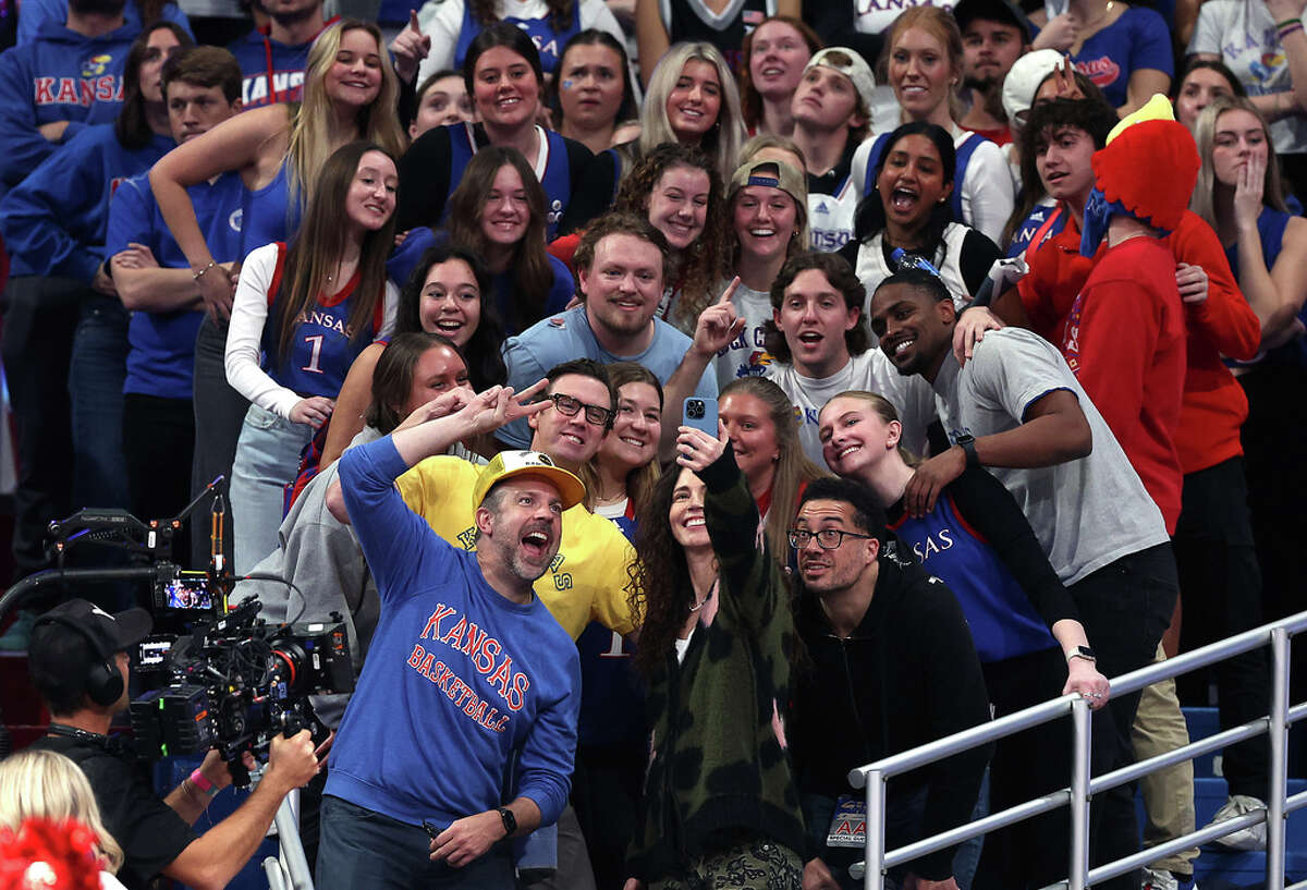 LAWRENCE, KANSAS - DECEMBER 01: Actor Jason Sudekis takes a selfie with fans during the 1st half of the game between the Connecticut Huskies and the Kansas Jayhawks at Allen Fieldhouse on December 01, 2023 in Lawrence, Kansas. (Photo by Jamie Squire/Getty Images)