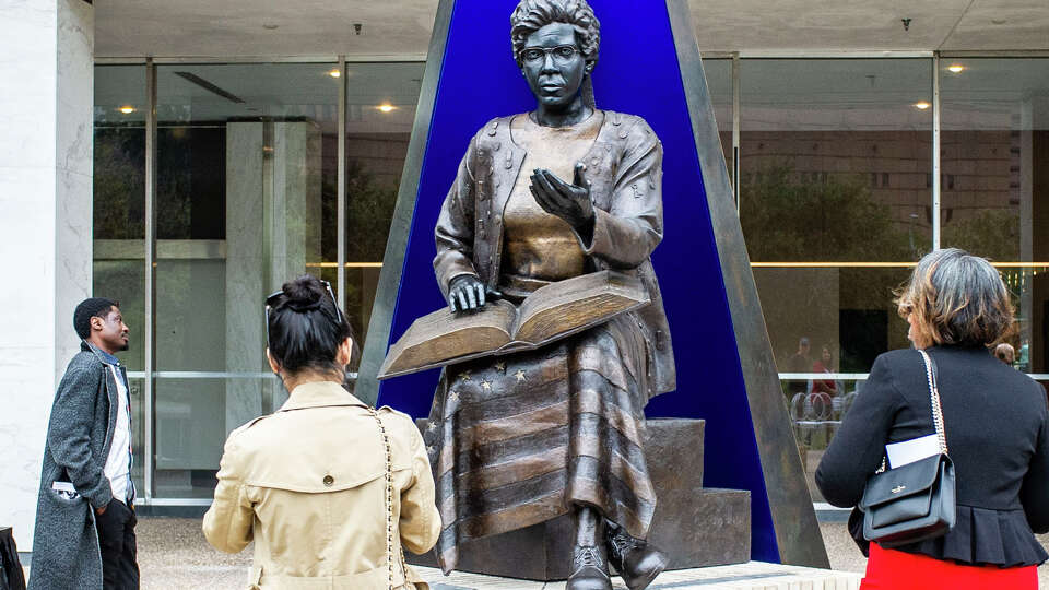 Abidemi Olowonira, Allison He and Kim Taylor pay their respects and admire the monument created in the image politician and civil rights activist Barbara Jordan following a dedication and unveiling ceremony Saturday, Dec. 2, 2023 in Houston.