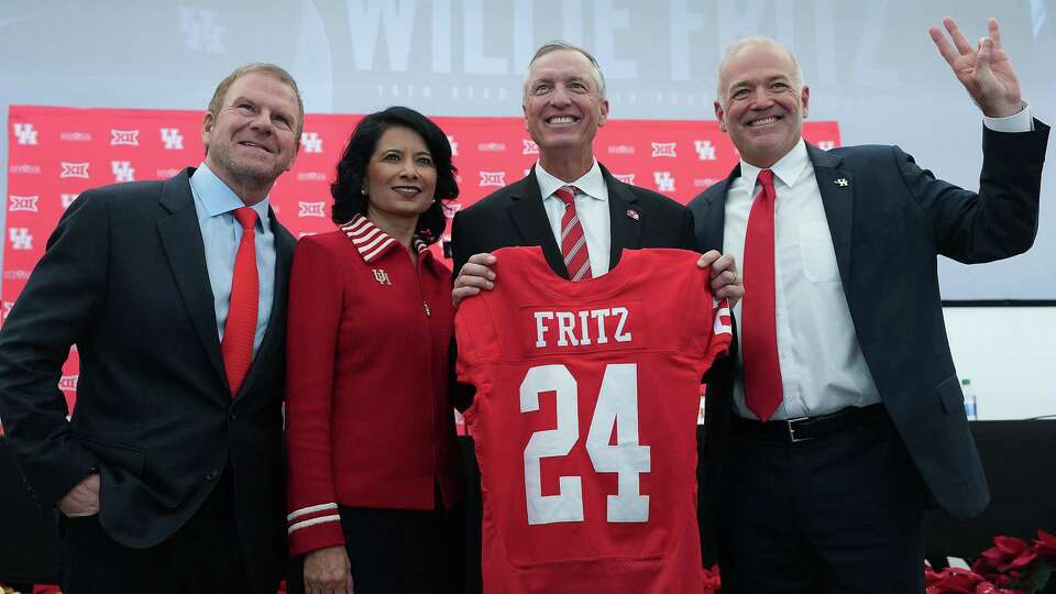 University of Houston head football coach Willie Fritz poses with a jersey with (from left) Tilman Fertitta, Chairman UH System Board of Regents, UH President Renu Khator, and Chris Pezman, VP for UH Athletics, on Monday, Dec. 4, 2023 in Houston.