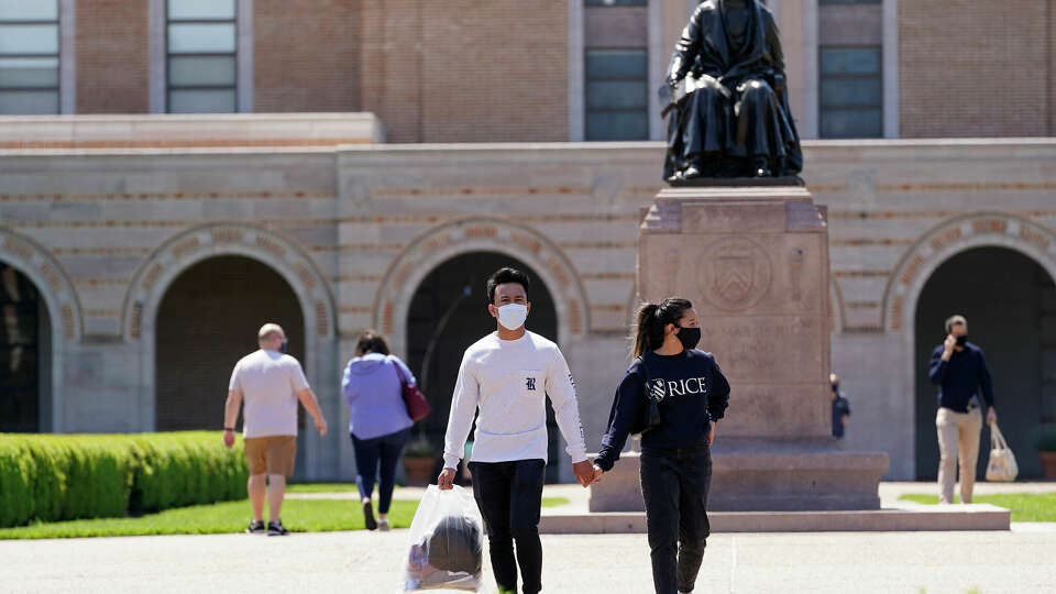 People walk on the campus of Rice University near the statue of the school's namesake, William Marsh Rice, Thursday, April 1, 2021 in Houston. Rice University has announced an expansion of its student body and its campus. The physical expansion on the college's 300 acres, will include a 12th residential college, a new engineering building, a building for the visual and dramatic arts, and a new student center that will largely replace the Rice Memorial Center.