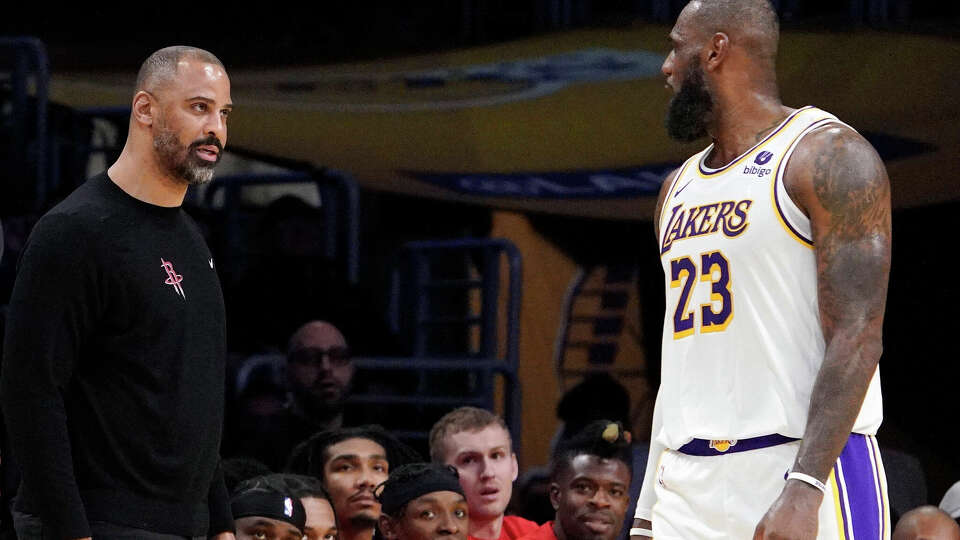 Houston Rockets head coach Ime Udoka, center, and Los Angeles Lakers forward LeBron James, right, exchange words during the second half of an NBA basketball game as referee J.T. Orr watches Saturday, Dec. 2, 2023, in Los Angeles. James and Udoka both received technical fouls soon after and Udoka was ejected from the game as that was his second technical foul. (AP Photo/Mark J. Terrill)