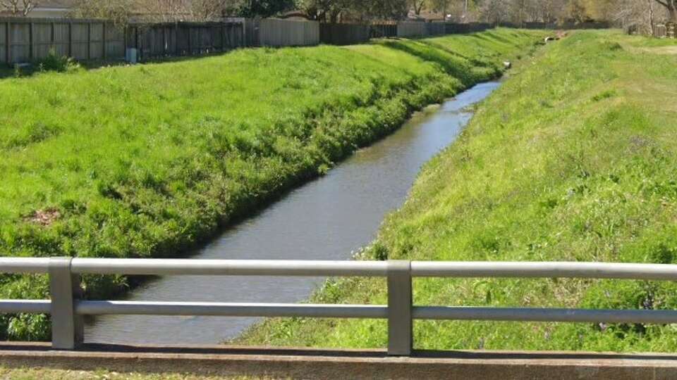 A channel in the Cypress Creek watershed, looking north from Cypresswood Drive in Spring, is shown in a Google Maps street view image from March 2022.