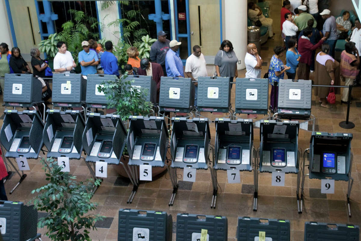 Voters line up beside empty voting booths inside the Acres Homes Mulit-Service Center to cast their votes on the first day of early voting Monday, Oct. 20, 2008, in Houston.(Brett Coomer / Chronicle) (Photo by Brett Coomer/Houston Chronicle via Getty Images)