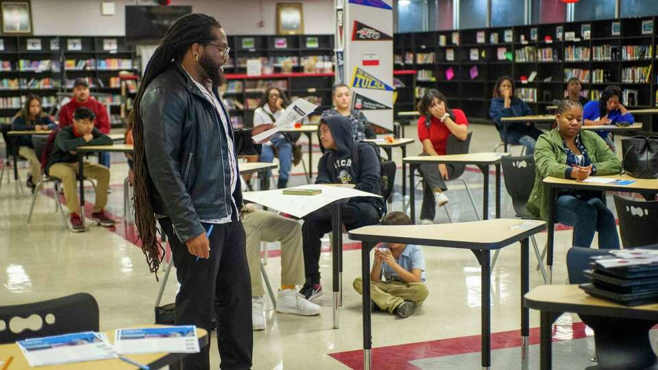 Fleming Middle School eighth graders and parents listen as English teacher, James Shropshire, provides details of a travel opportunity to Japan being offered free of charge to students as part of the HISD extra curricular DYAD program in Houston.