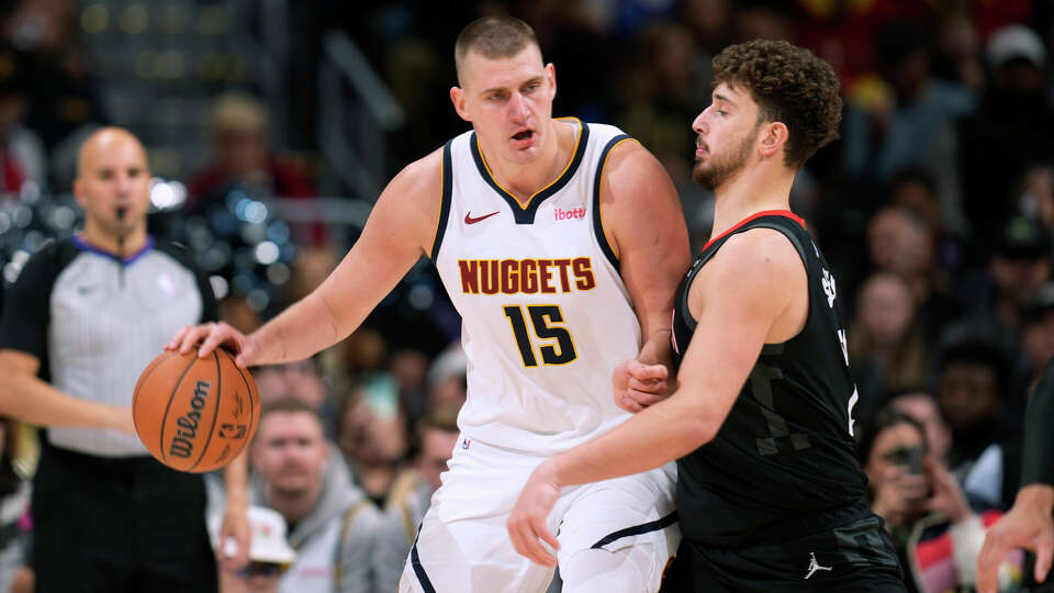 Denver Nuggets center Nikola Jokic, left, is defended by Houston Rockets center Alperen Sengun during the second half of an NBA basketball game Friday, Dec. 8, 2023, in Denver. (AP Photo/David Zalubowski)