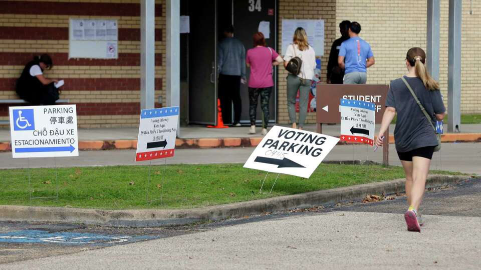 Voters head to the polling place off the the parking lot of Memorial Middle School Saturday, Dec. 9, 2023 in Houston.