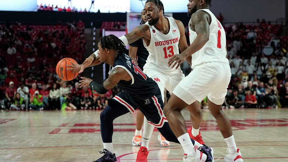 Jackson State guard Chase Adams (10) fights out of a double team by Houston forward J'Wan Roberts (13) and guard Jamal Shead (1) during the first half of an NCAA college basketball game, Saturday, Dec. 9, 2023, in Houston. (AP Photo/Kevin M. Cox)