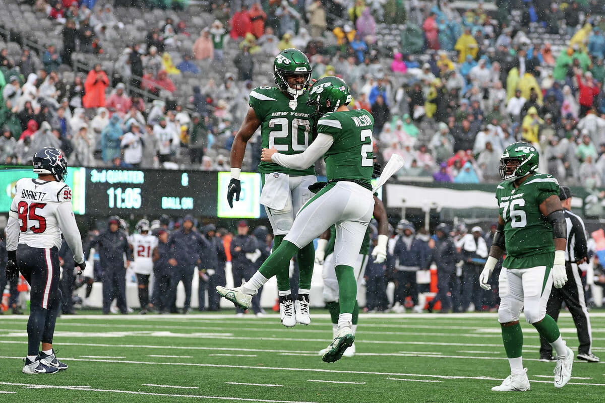 Breece Hall #20 and Zach Wilson #2 of the New York Jets celebrates after a touchdown during the third quarter in the game against the Houston Texans at MetLife Stadium on December 10, 2023 in East Rutherford, New Jersey.