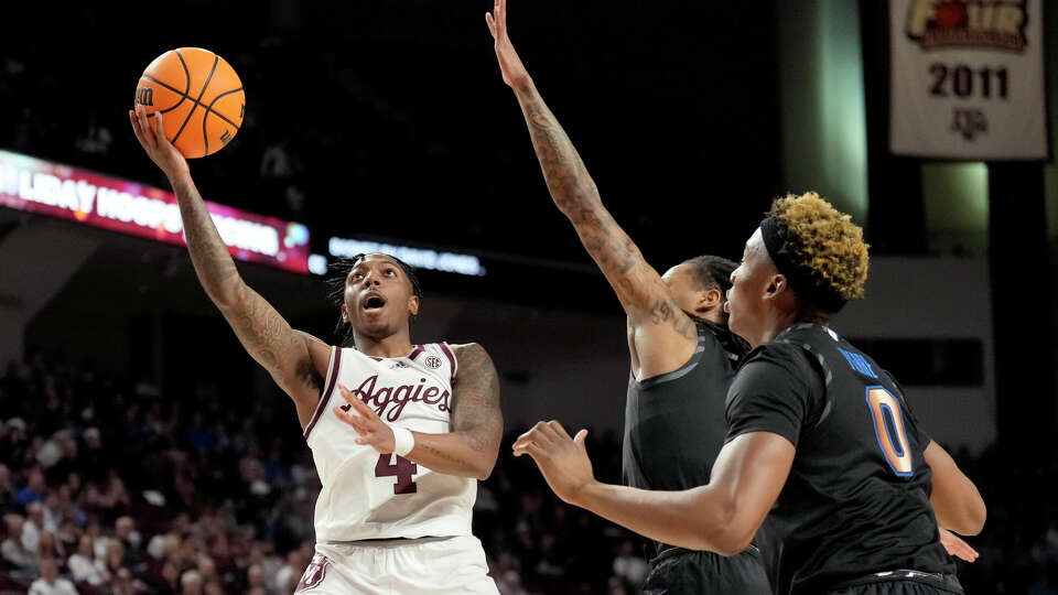 Texas A&M guard Wade Taylor IV (4) shoots the ball past Memphis guard Jaykwon Walton (10) and forward Jonathan Pierre (0) during the first half of an NCAA college basketball game, Sunday, Dec. 10, 2023, in College Station, Texas. (AP Photo/Sam Craft)