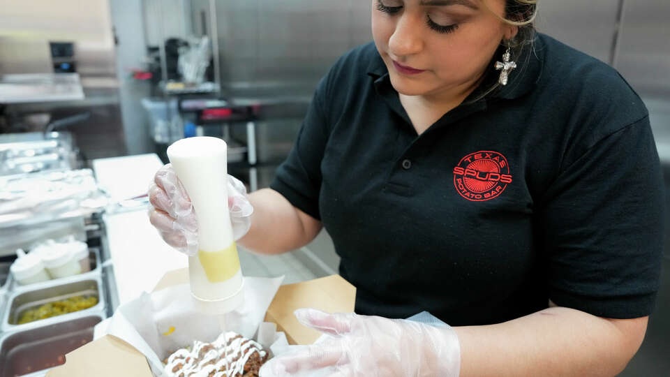 Spuds Potato Bar Executive Chef Gabriella Pitts fulfills an order on Thursday, Dec. 7, 2023 in Montgomery.