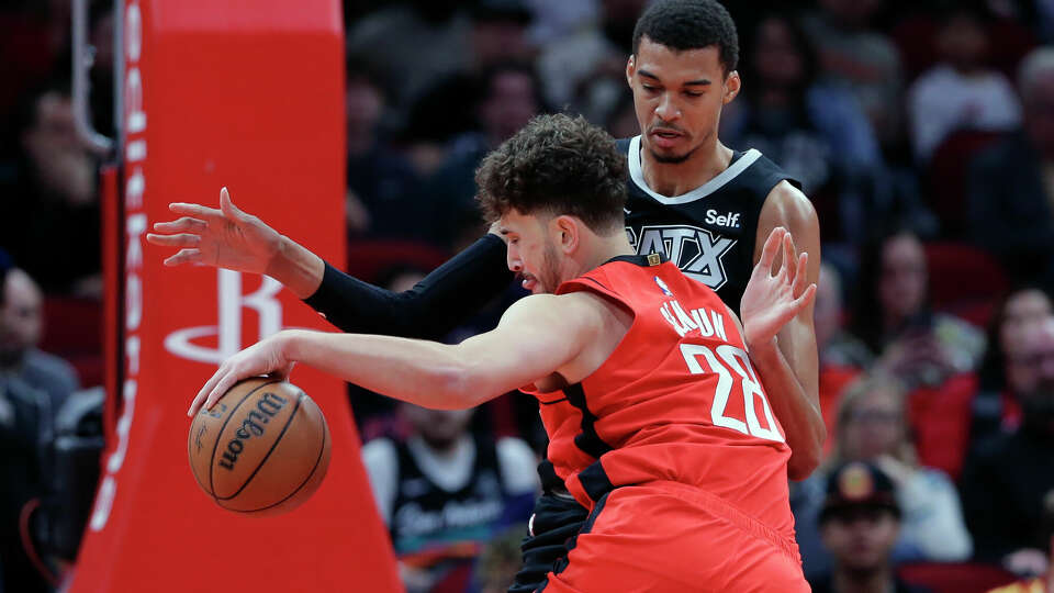 Houston Rockets center Alperen Sengun collides on a drive to the basket with San Antonio Spurs center Victor Wembanyama, right, during the first half of an NBA basketball game, Monday, Dec. 11, 2023, in Houston. (AP Photo/Michael Wyke)