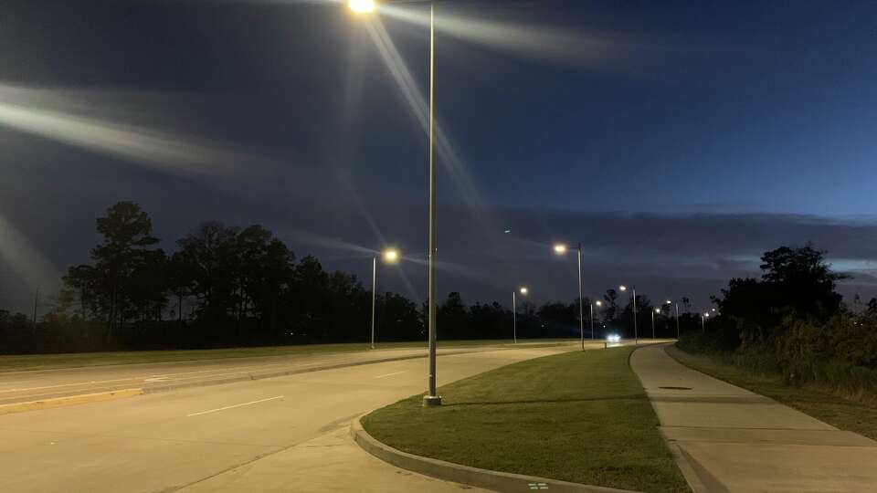 Cars drive down a well-lit area on West Lake Houston Parkway just before 6 p.m. on Monday, Dec. 11, 2023. Residents across Houston will now be able to get streetlights installed for free with the city council's vote to remove the $200 fee associated with the installation. 