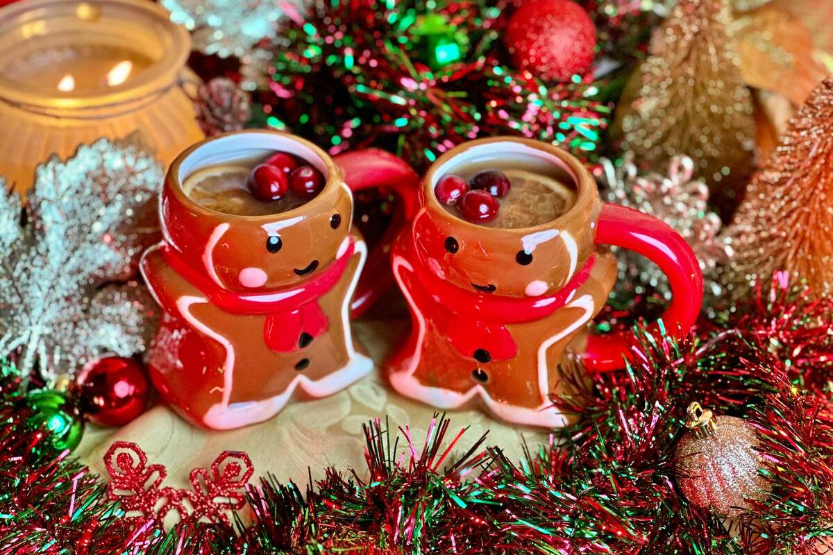 The Winter Solstice Wassail cocktail is poured into gingerbread man mugs.