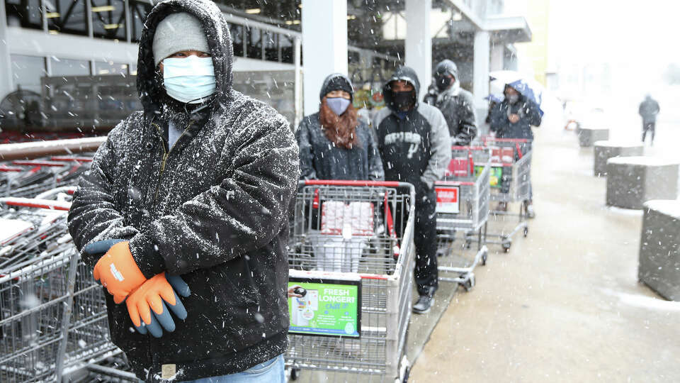 Alex Vega (left) waits with others to shop the HEB at Wurzbach Road during another day of snow fall in San Antonio on Thursday, Feb 18, 2021. Items like milk, eggs and meats were not available and water was limited.