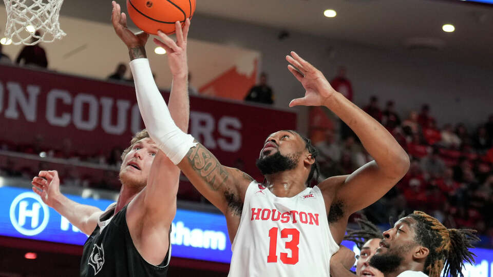 Houston Cougars forward J'Wan Roberts (13) goes up for a rebound against Rice Owls forward Max Fiedler (15) during the second half of an NCAA college basketball game at the Fertitta Center, Wednesday, Dec. 6, 2023, in Houston.