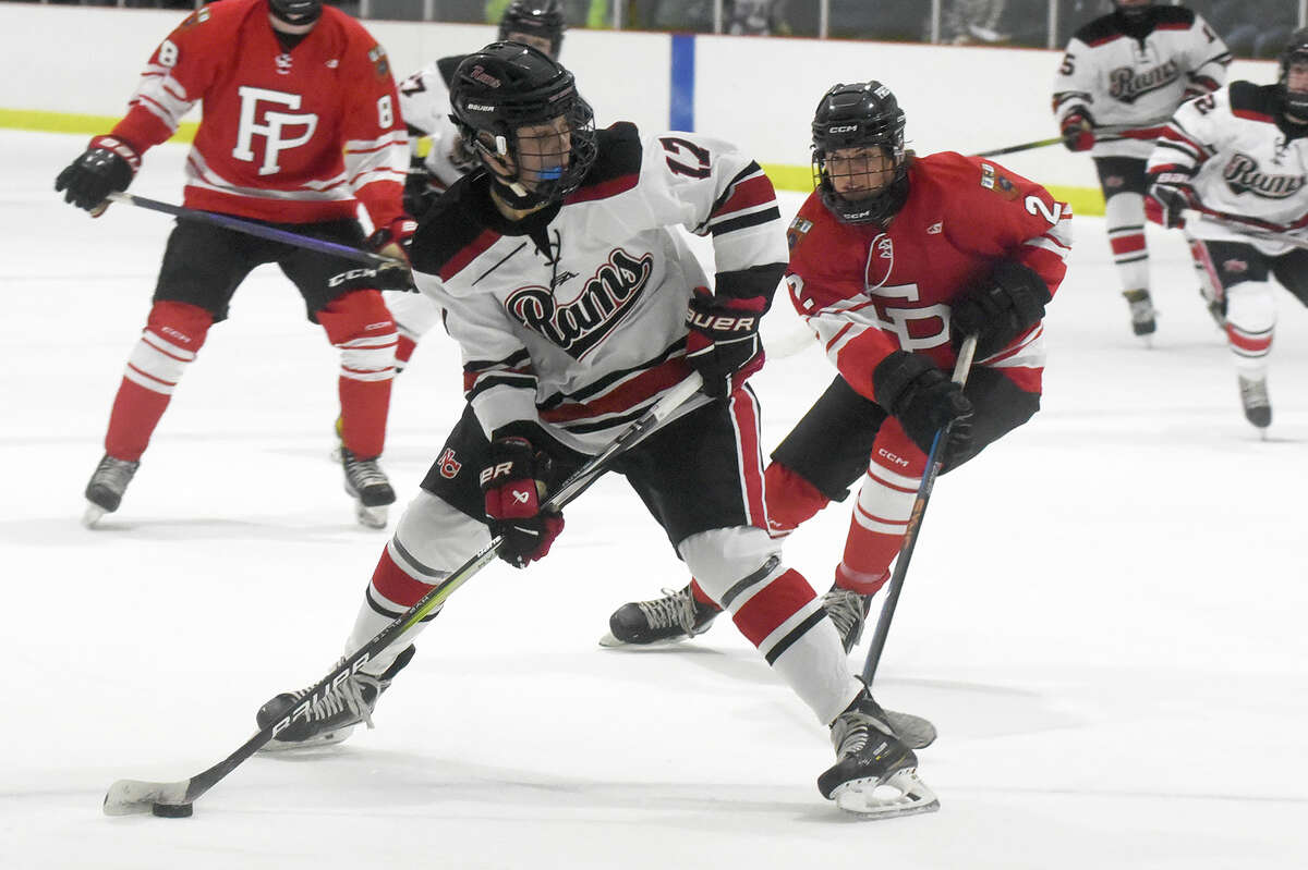 New Canaan's Jack Thompson (17) controls the puck while Fairfield Prep's Tyler Shehaj (2) defends during a boys ice hockey game at the Darien Ice House on Friday, Dec. 15, 2023.