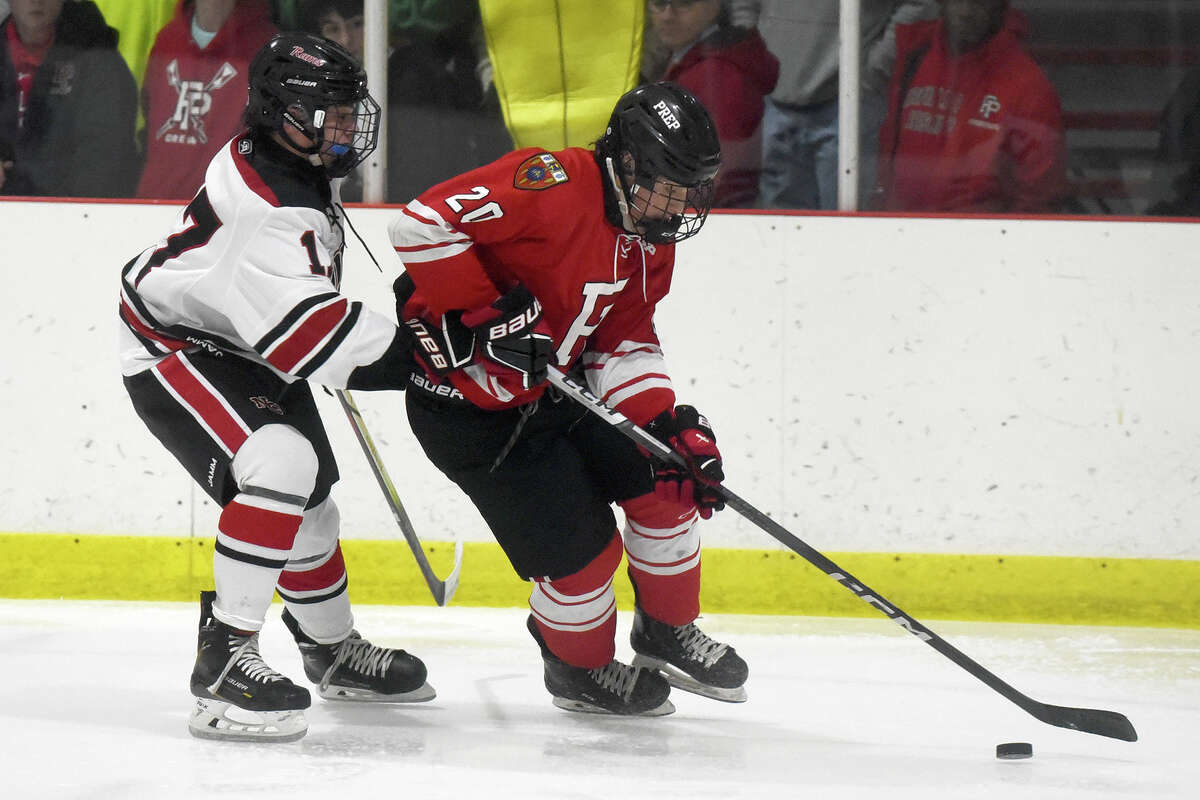 Fairfield Prep's Hudson Wingate (20) controls the puck in front of New Canaan's Jack Thompson (17) during a boys ice hockey game at the Darien Ice House on Friday, Dec. 15, 2023.