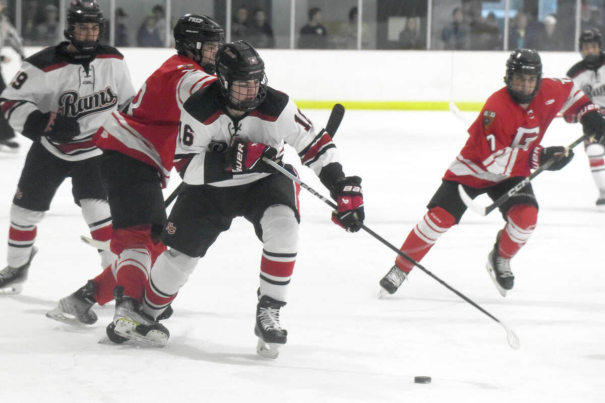 New Canaan's Bryce Lyden (16) battles for the puck against Fairfield Prep during a boys ice hockey game at the Darien Ice House on Friday, Dec. 15, 2023.