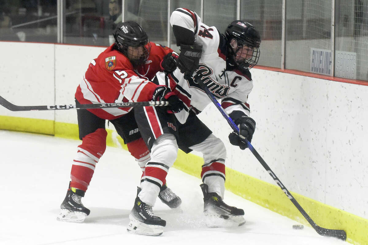 New Canaan's Gavin Fitzpatrick (14) and Fairfield Prep's Gavin Burke (15) battles along the boards during a boys ice hockey game at the Darien Ice House on Friday, Dec. 15, 2023.