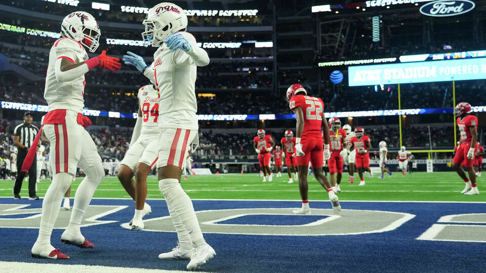 North Shore players walk back to the huddle as Duncanville tight end Zach Turner (9) and wide receiver Dakorien Moore (1) celebrate Turner's 75-yard touchdown during the second half of the 6A Division I UIL state championship game at AT&T Stadium, Saturday, Dec. 16, 2023, in Arlington.