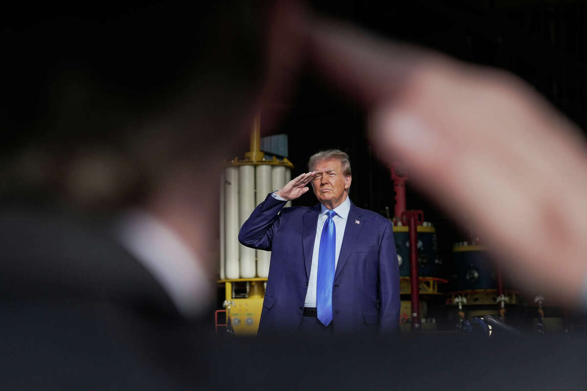 Former President Donald Trump salutes during the pledge of allegiance as he makes a campaign stop on Thursday, Nov. 2, 2023, in Houston.