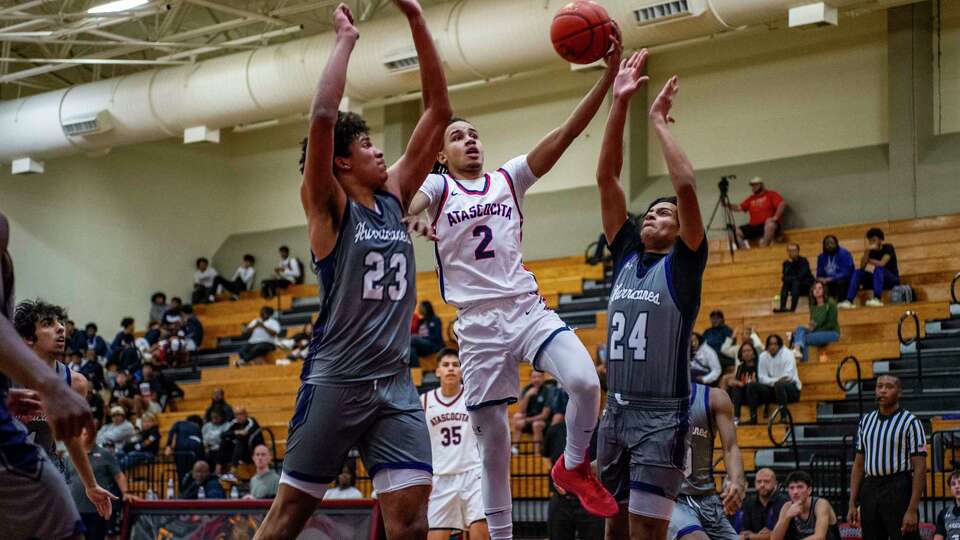 Atascocita's Jachai Cantave (2) lays up a shot over Klein Cain's John Clark (23) and Colin Mutayoba (24) In the first half of a boys high school basketball game Tuesday, Dec. 19, 2023 at Atascocita High School.